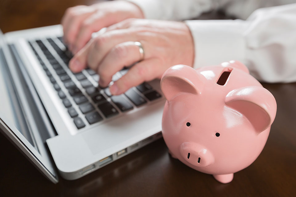 Photo of piggy bank with laptop